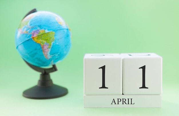 Calendario primavera 11 aprile. Parte di un set su sfondo sfocato verde e globo.