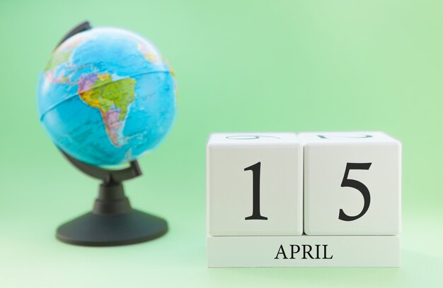 Calendario primavera 15 aprile. Parte di un set su sfondo sfocato verde e globo.