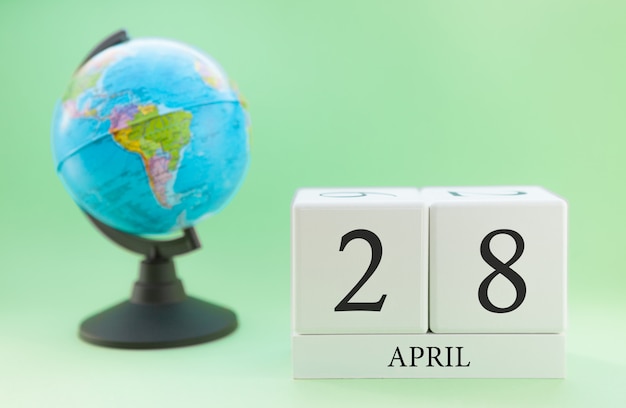 Calendario primavera 28 aprile. Parte di un set su sfondo sfocato verde e globo.