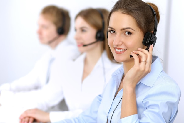 Call center. Concentrarsi sulla bella donna in cuffia.