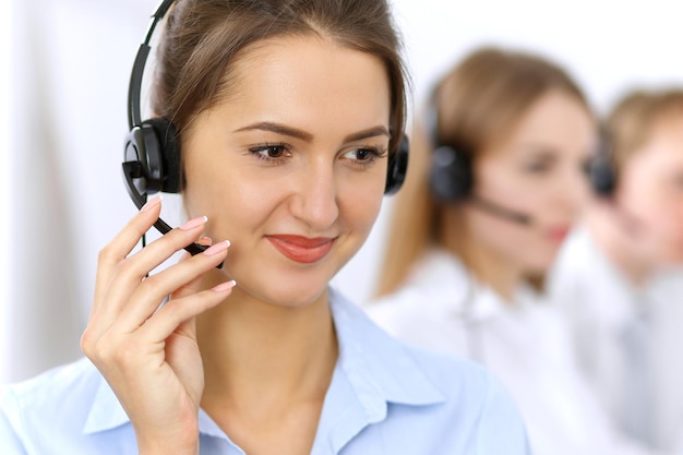 Call center. Concentrarsi sulla bella donna in cuffia.