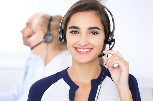 Call center. Concentrarsi sulla bella donna in cuffia.