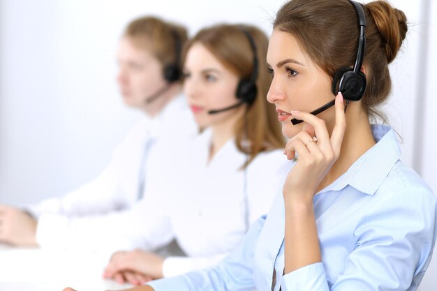 Call center. Concentrarsi sulla bella donna in cuffia.