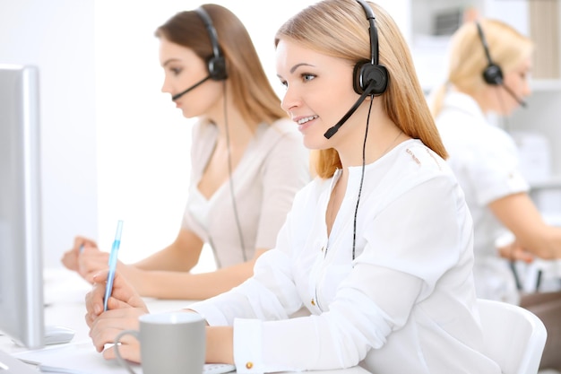 Call center. Concentrarsi sulla bella donna in cuffia.