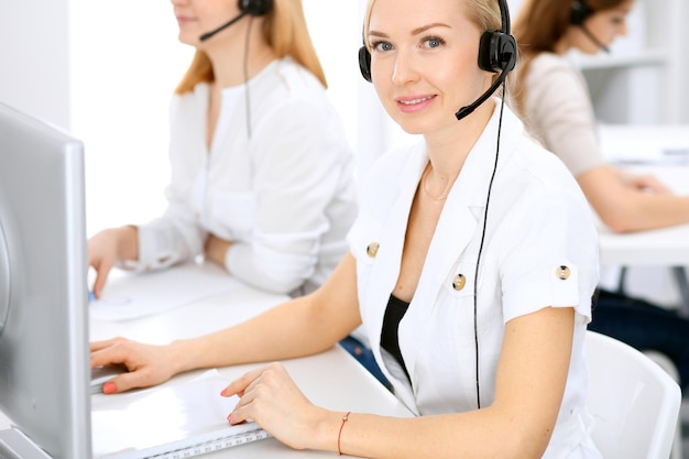 Call center. Concentrarsi sulla bella donna in cuffia.