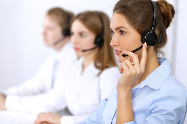 Call center. Concentrarsi sulla bella donna in cuffia.