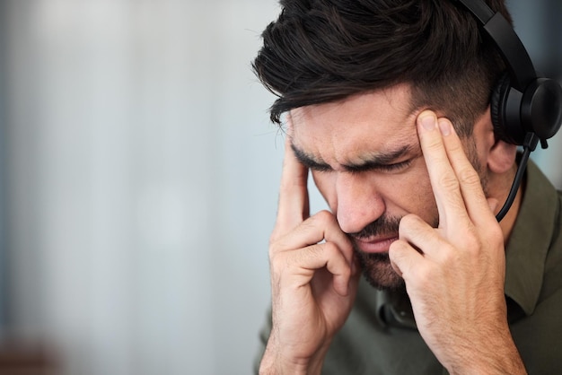 Call center di telemarketing e uomo con mal di testa burnout e supporto tecnico con dolore da stress e straordinari Impiegato o consulente di sesso maschile con emicrania affaticamento per la salute e agente con tensione