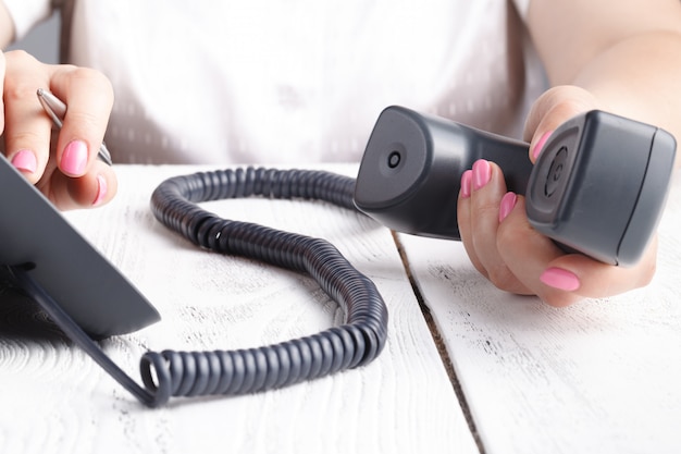 Call center o ufficio telefono concetto, dito femminile premere il numero sul pad del telefono