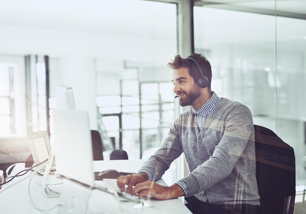 call center typing and business man on computer in office for customer service telemarketing smile and male person on pc sales agent or consultant working for support consulting and help online