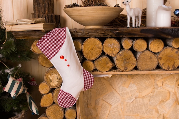 Calza di Natale a quadretti appesa al mantello del camino in legno rustico