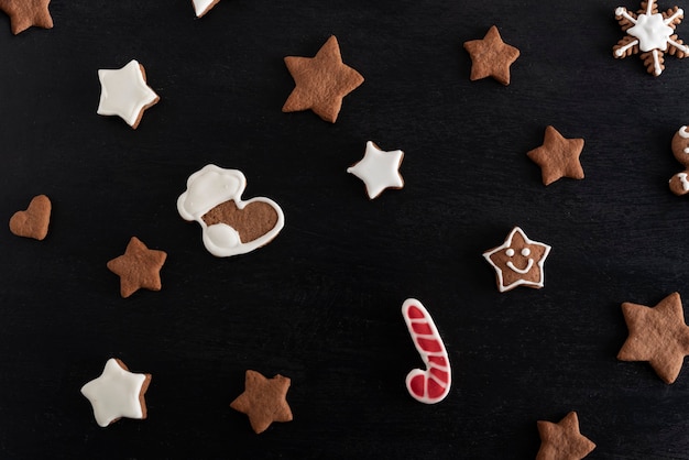 Calza di Natale e stelle di pan di zenzero su sfondo nero. Pasticceria tradizionale.