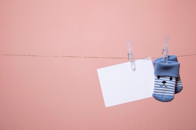 Calzini per bambini carini con una faccia e una carta bianca appesa a una linea di vestiti