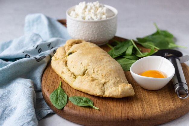 Calzone chiuso per pizza con spinaci, pollo e ricotta. Cibo italiano.