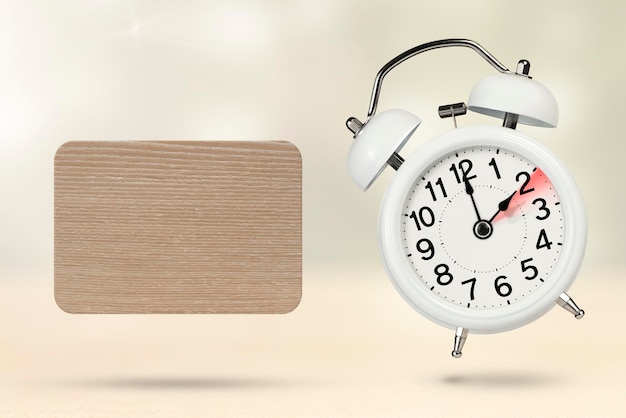Cambia il tempo orario invernale concetto su uno sfondo di legno una sveglia bianca con una lancetta dei minuti indica