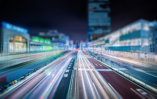 Cambiamento di inclinazione dei sentieri di luce sulla strada in mezzo agli edifici della città di notte