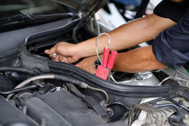 cambiare la batteria dell'auto il meccanico sta controllando il motore