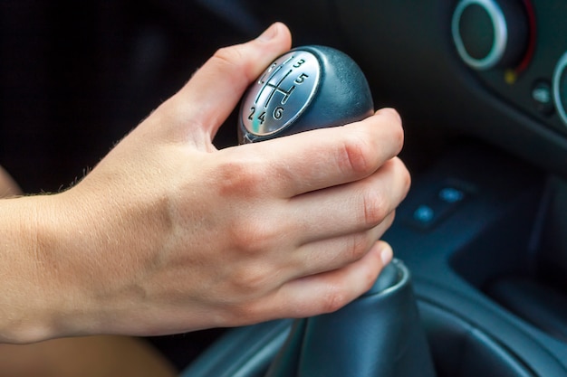 Cambio manuale della mano del conducente. Ragazza alla guida di un'auto