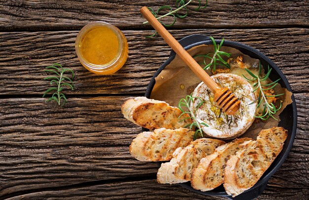 Camembert al formaggio al forno con rosmarino e miele. Cibo gustoso. Vista dall&#39;alto. Distesi