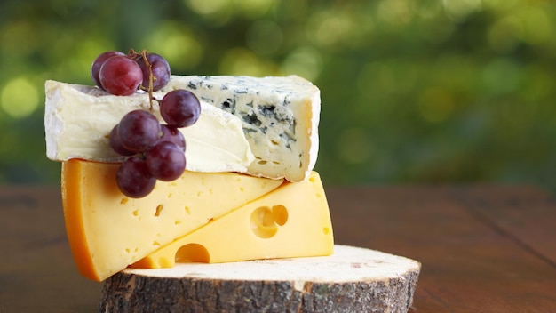 Camembert brie formaggio duro e formaggio blu su tavola di legno Fette di vari formaggi