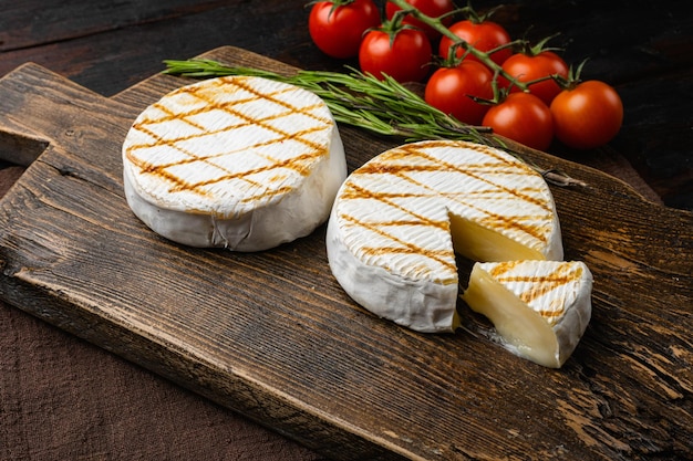 Camembert con retro del forno sul vecchio fondo della tavola di legno scuro