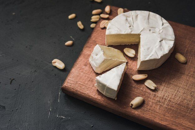 Camembert di formaggio con muffa e noci su tavola di legno