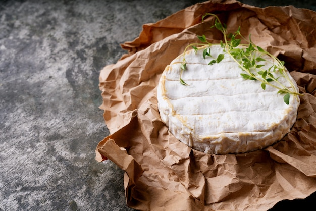 Camembert di formaggio francese alle erbe su carta