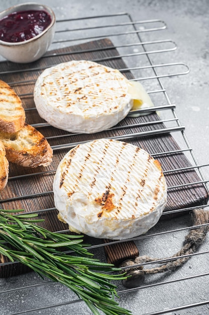 Camembert grigliato alla griglia con salsa di mirtilli e pane tostato Sfondo grigio Vista dall'alto