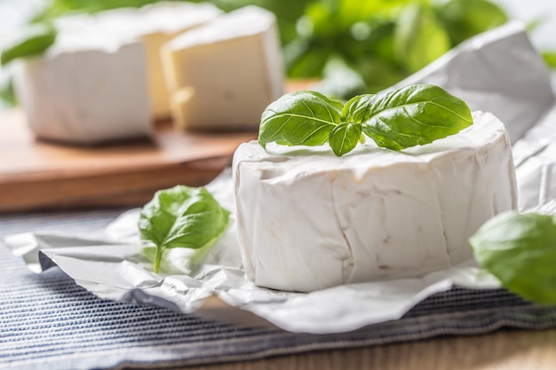 Camembert o formaggio brie con foglie di basilico sul tavolo.