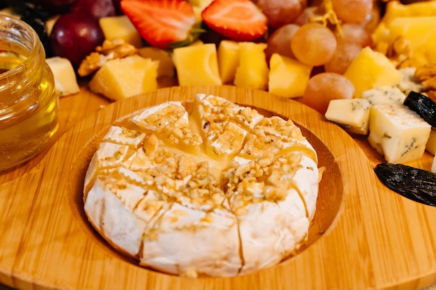 Camembert. vassoio in legno con formaggio, frutta e miele. delizioso delizioso spuntino per il banchetto. Ristorazione.