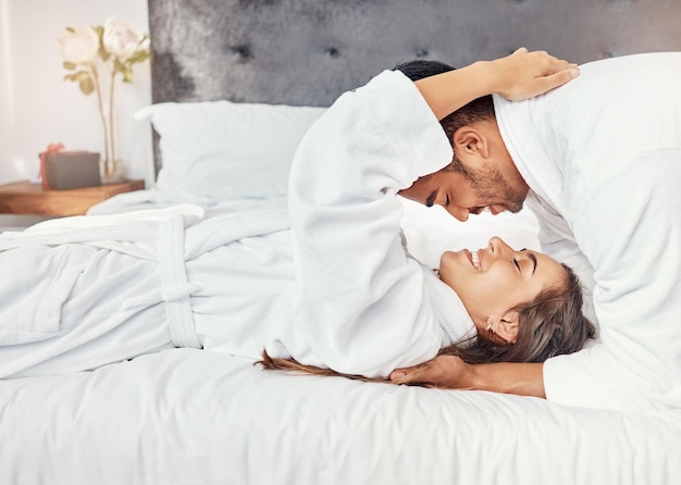 Camera da letto dell'hotel per le vacanze di coppia e felice in vacanza di lusso per la celebrazione del matrimonio sorriso per amore sul letto e abbraccio di felicità insieme in casa L'uomo e la donna si rilassano con il romanticismo nell'appartamento della casa