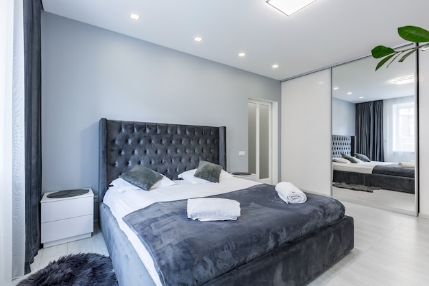 camera da letto moderna con letto grande in colori scuri grigio