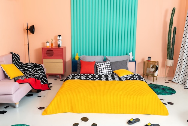 Camera da letto multicolore con motivi geometrici negli interni e in tessuto.