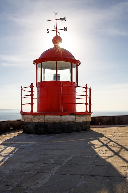 Camera rossa della lampada del faro sul cielo blu e sullo sfondo del mare