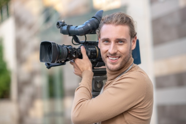 Cameraman tenendo la fotocamera sulla spalla