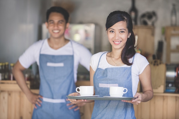 Cameriera asiatica che serve caffè