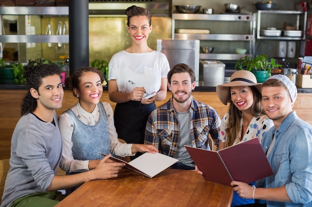 Cameriera di bar e clienti sorridenti in ristorante