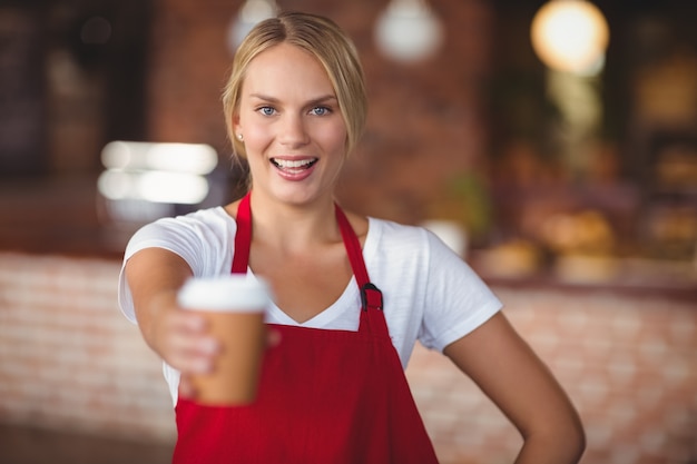 Cameriera graziosa che passa una tazza di caffè