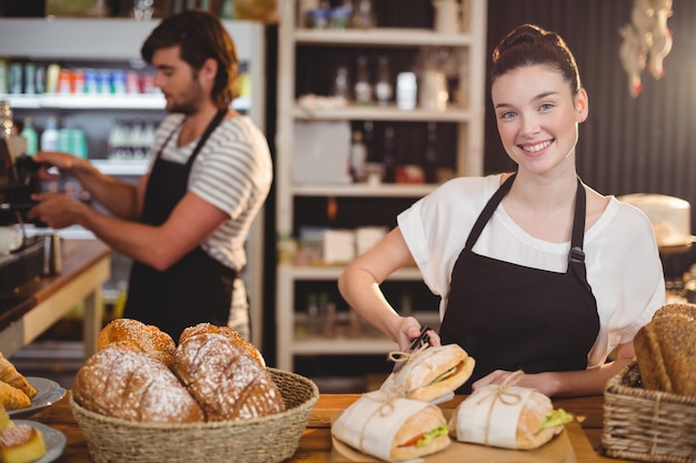 cameriera in piedi al bancone con panini e panini