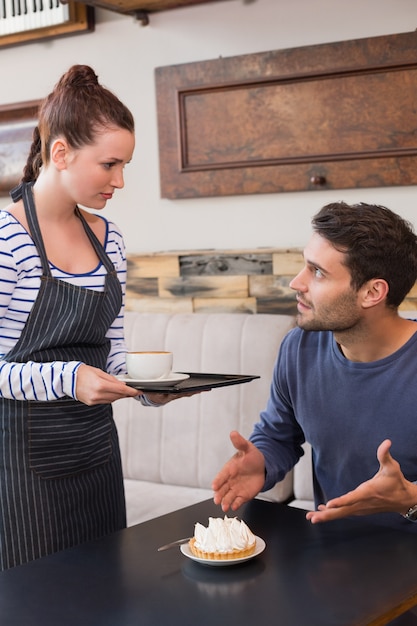 Cameriera portando caffè e crostata all&#39;uomo