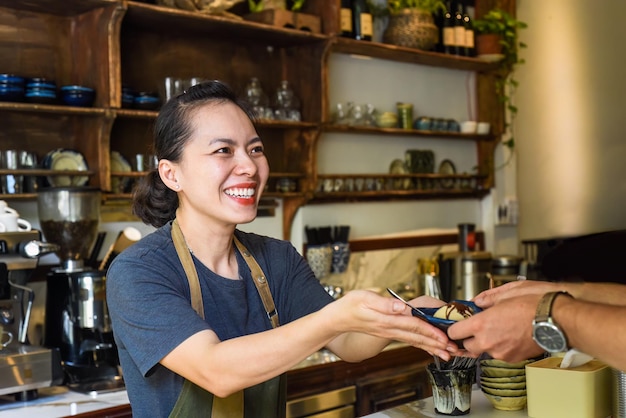 Cameriera vietnamita che serve gelato per un cliente in una caffetteria