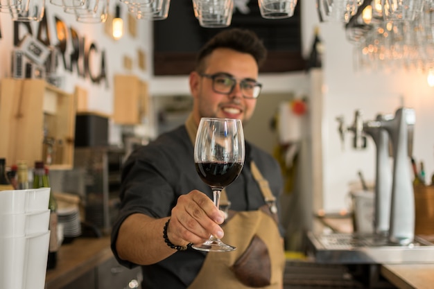 Cameriere che offre una tazza di vino in un pub