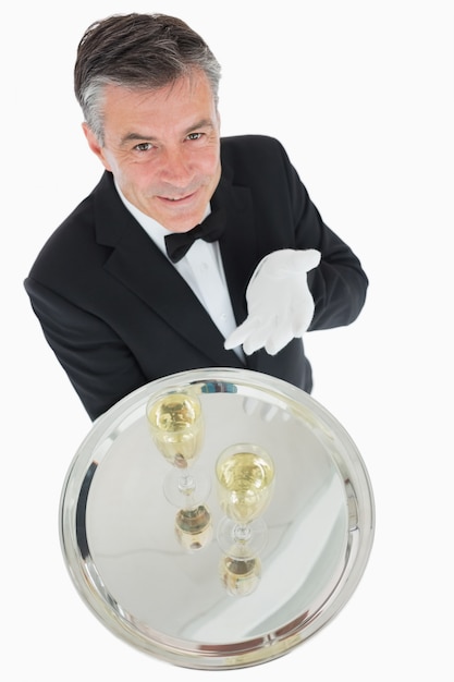 Cameriere che offre vassoio con bicchieri di champagne