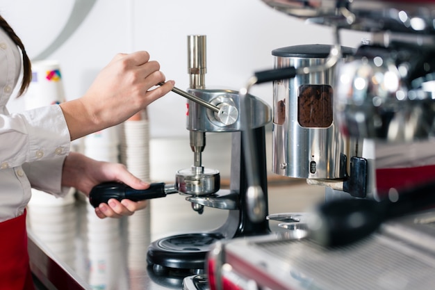 Cameriere che prepara caffè espresso a una macchina da caffè automatica