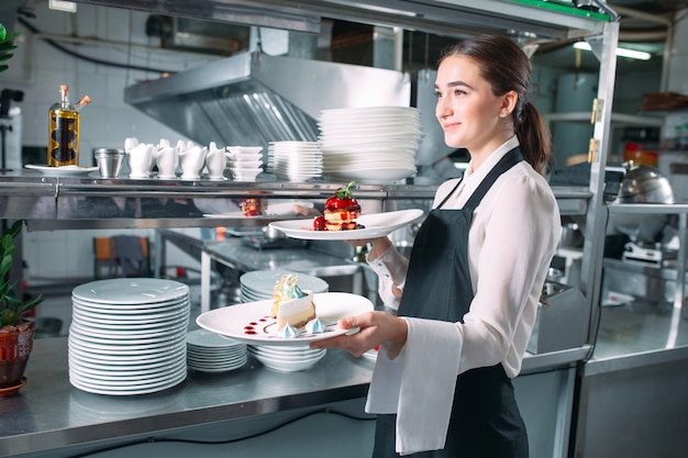 Cameriere che serve in movimento in servizio nel ristorante. Il cameriere porta i piatti