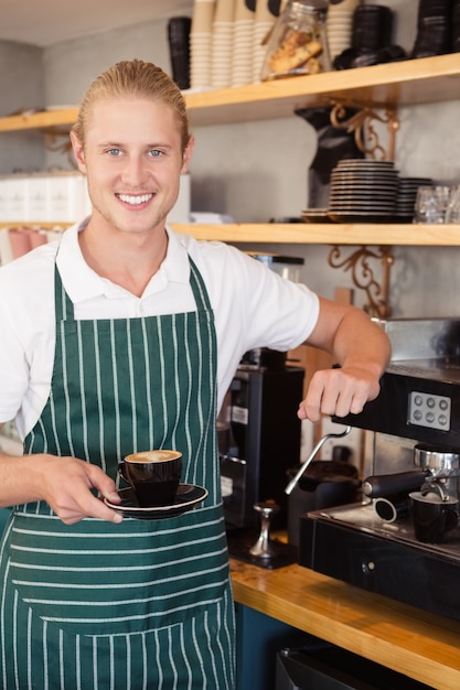 Cameriere che tiene una tazza di caffè