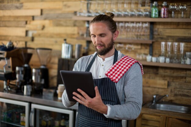 Cameriere che utilizza compressa digitale nel caffè