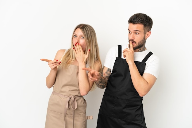 Cameriere del ristorante su sfondo bianco isolato che punta il dito sul lato con una faccia sorpresa