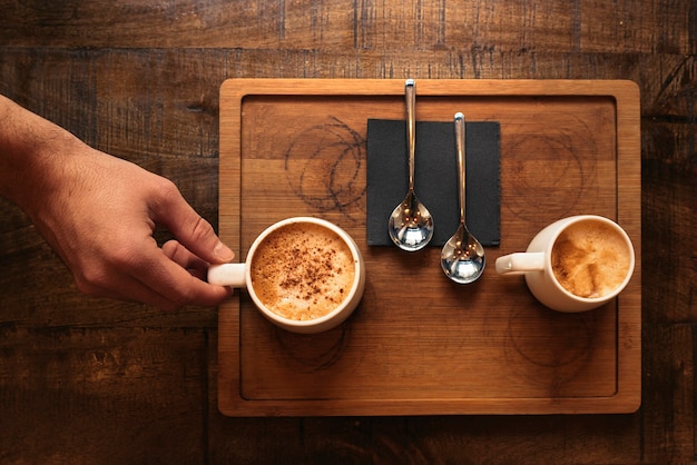 Cameriere in possesso di un vassoio con caffè al bar.