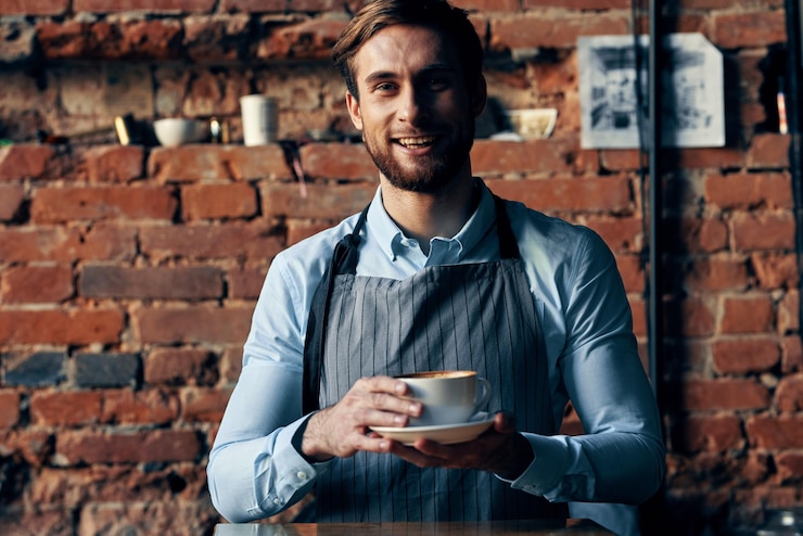 Foto cameriere maschio che indossa lo stile di vita di servizio tazza di caffè grembiule