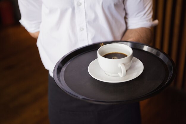 Cameriere tenendo il vassoio con una tazza di caffè